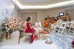 Indoor Ceremony with Floral Decor and Guests in Traditional Attire