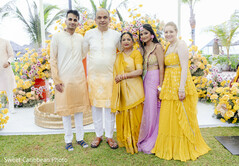 Family group photo in yellow and pink attire with floral decor
