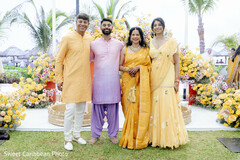 People in yellow and lavender outfits with floral decor