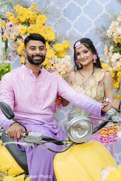 Couple on yellow scooter with floral backdrop