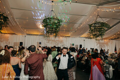 Lively Reception Dance Floor Under Greenery Chandeliers