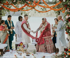 Couple Under Floral Mandap with Red and White Outfits