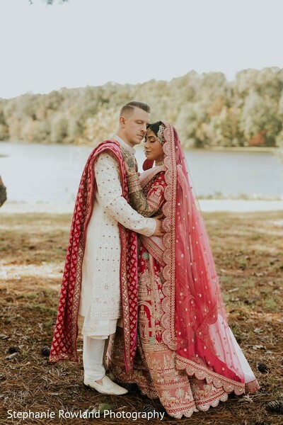 red lehenga,white sherwani,bridal fashion,groom fashion,outdoor portraits,embroidered lehenga,pink dupatta,couple portrait,wedding attire