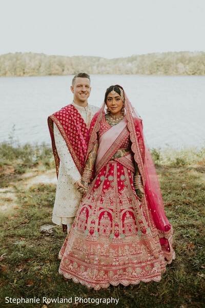 outdoor portraits,couple,bride,groom,lehenga,sherwani,pink lehenga,red lehenga,embroidered lehenga,ivory sherwani,red dupatta,lake background