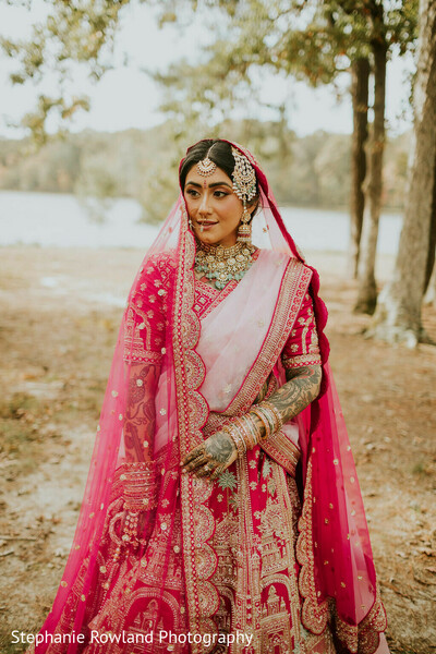red lehenga,bridal jewelry,outdoor portrait,choker,maang tikka,bridal fashion,embroidered lehenga,wedding attire,bridal headpiece,bridal bangles