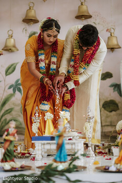 Couple performs ceremony ritual in traditional attire with bells