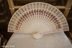 Intricate Wooden Hand Fan Wedding Favor on Chair