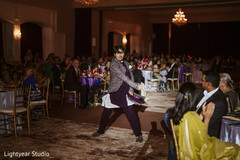Guest dancing in purple kurta and patterned jacket at wedding reception