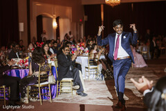 Wedding guest dancing in blue suit at elegant reception