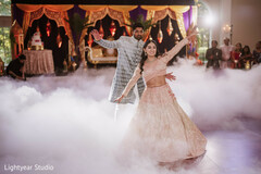 Couple dancing on fog-filled stage with ornate gold decor