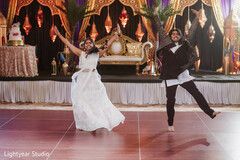 Guests dancing on stage with ornate gold and purple decor