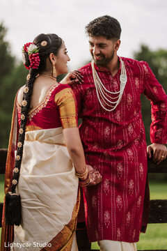 Couple in red and cream attire with braided hair