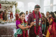 Couple in traditional attire with floral garlands at wedding ceremony