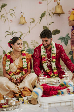 Couple in traditional attire with floral garlands during ceremony