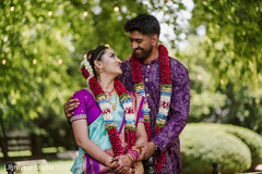 Couple in wedding attire with floral garlands