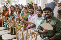 Wedding guests in traditional attire enjoying drinks at a celebration