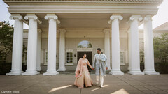 Couple in traditional attire in front of a building with columns