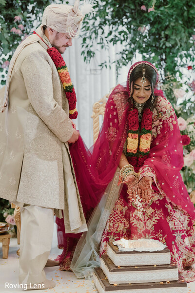 cake cutting,wedding reception,bride and groom,reception traditions,bridal lehenga,ivory sherwani,celebration,newlyweds,candid moment,south asian wedding