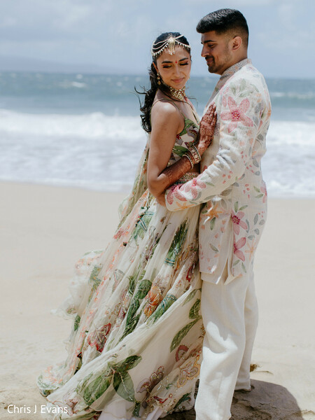 beach portraits,floral outfits,destination wedding,ocean backdrop,couple embrace,romantic portraits,seaside wedding,tropical wedding,coordinated fashion,south asian wedding