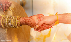 Close-up of hands adorned with mehndi and bangles