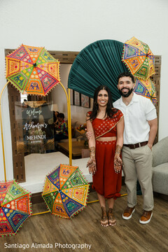Couple Poses by Colorful Umbrellas and Mehndi Welcome Sign