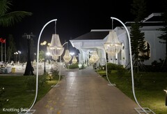 Elegant Pathway Adorned with Hanging Chandeliers Leading to a Building Entrance at Night