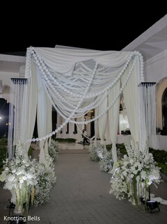 Elegant White Draped Entrance with Beaded Garlands and Floral Arrangements