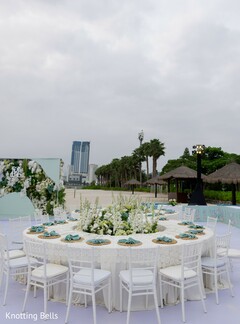 Outdoor Reception Table with White Floral Centerpiece and Teal Napkins
