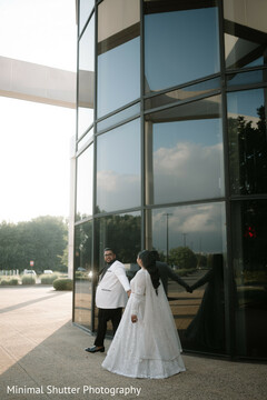 Couple Poses by Modern Glass Building