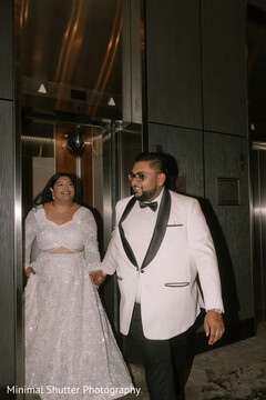 Stylish Couple Exits Elevator in Chic White and Black Attire