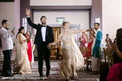 Joyful Couple's Grand Entrance in Elegant Gold and Black Attire