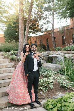 Couple Poses in Pink Floral Lehenga and Black Tuxedo in Garden