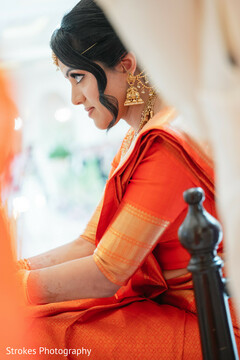 Bride in Profile with Ornate Gold Jhumkas and Orange Saree