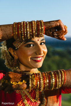 Smiling Bride with Red and Gold Bangles and Floral Hair Adornment