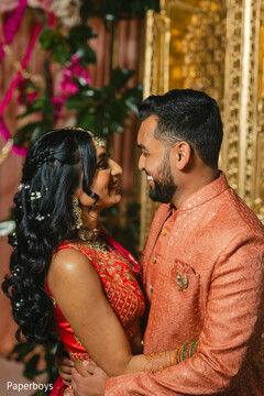 Couple's Portrait: Red Lehenga and Red Sherwani with White Floral Hair Adornments