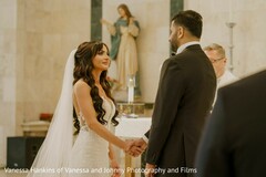 Bride in White Gown Holds Hands with Groom During Ceremony