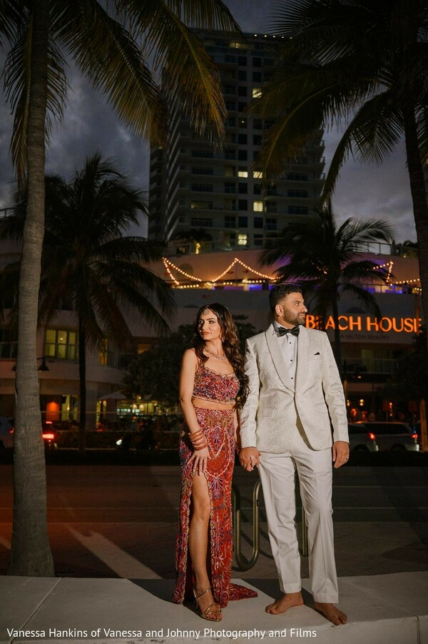 couple portrait,red patterned outfit,cream suit,nighttime photography,city lights,outdoor portrait