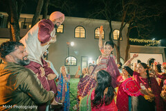 Joyful South Asian Couple Carried Amidst Cheering Wedding Guests