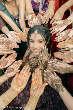 Woman Adorned with Intricate Mehndi Designs Surrounded by Women