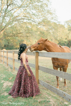 Bride in Maroon Lehenga with Floral Hair Accents and Horse