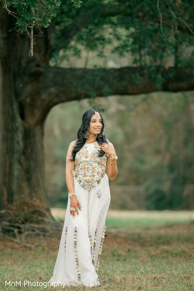 bride,white outfit,floral embroidery,halter top,palazzo pants,maang tikka,earrings,bangles,mehndi,outdoor portrait,pre-wedding fashion