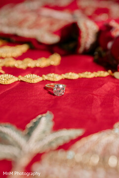 Sparkling Diamond Engagement Ring on Red Fabric with Gold and Silver Embroidery