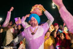Man Holds Decorative Lit Turban While Dancing