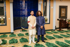 Groomsmen in Elegant Kurta Outfits Against Blue Tiled Wall