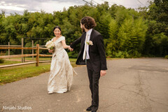 Romantic Outdoor Portrait of Bride in White Gown Leading Groom