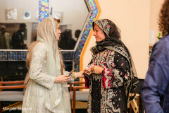 Two Women in Embroidered Outfits in Conversation