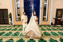 Joyful Bride Twirls in Ivory Lehenga with Groom in Elegant Sherwani