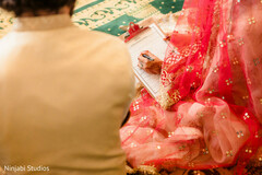 Intimate Moment: Bride Signing Wedding Documents in Red Attire