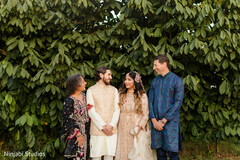 Bride and Groom with Guests Against Lush Green Foliage