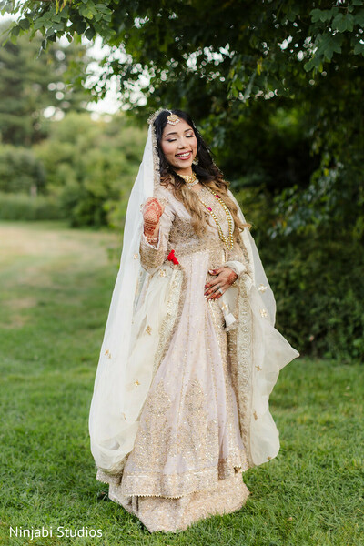 south asian wedding,bridal portrait,ivory anarkali,gold embroidery,bridal dupatta,outdoor wedding,bridal jewelry,maang tikka,wedding fashion,happy bride